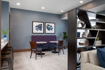 A modern living room with a purple couch and a wooden table.at The Edison at Spirit, Lakeville, MN 55044