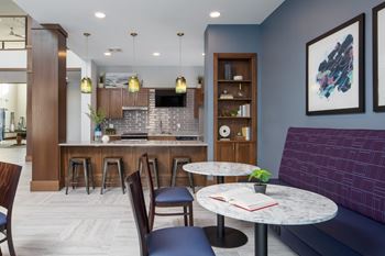 A modern kitchen with a bar area and seating.at The Edison at Spirit, Lakeville, MN 55044