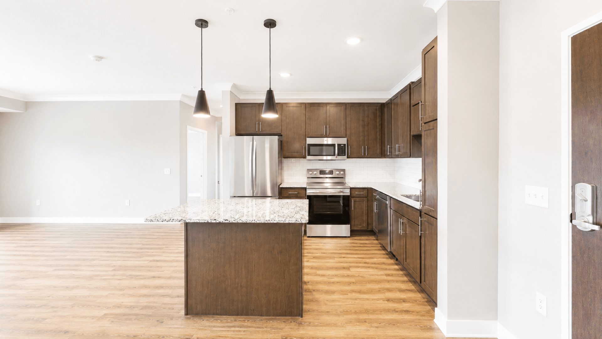 A kitchen with a white island and wooden floors.
