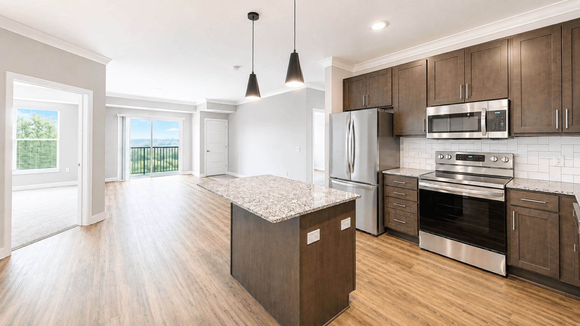 A kitchen with a granite counter top and stainless steel appliances.