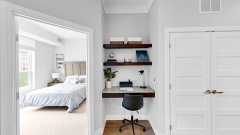 A bedroom with a bed, desk, and chair.
