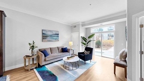 A living room with a couch, chair, and a painting on the wall.