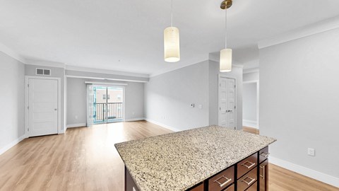 A spacious room with a granite countertop and wooden flooring.