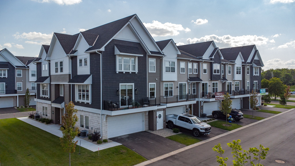 a row of townhouses with cars parked in front of them