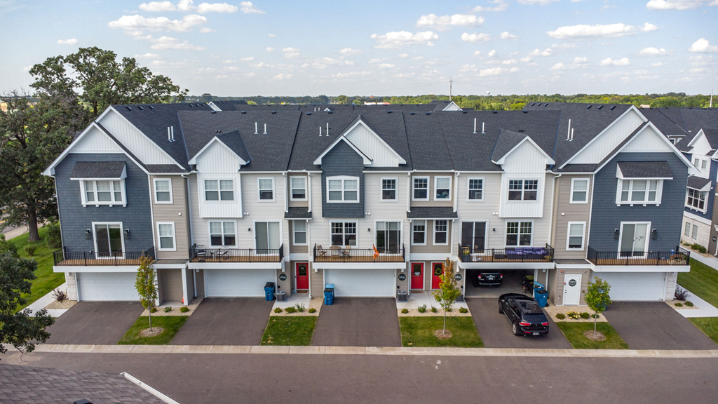 an aerial view of a townhome community with cars parked in front of it