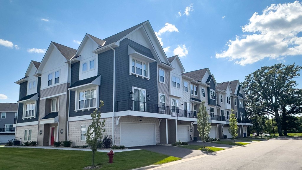a row of town houses on a street with a sidewalk