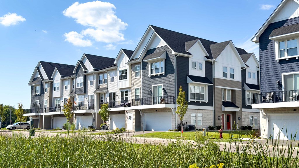 a row of houses on a street with grass in front