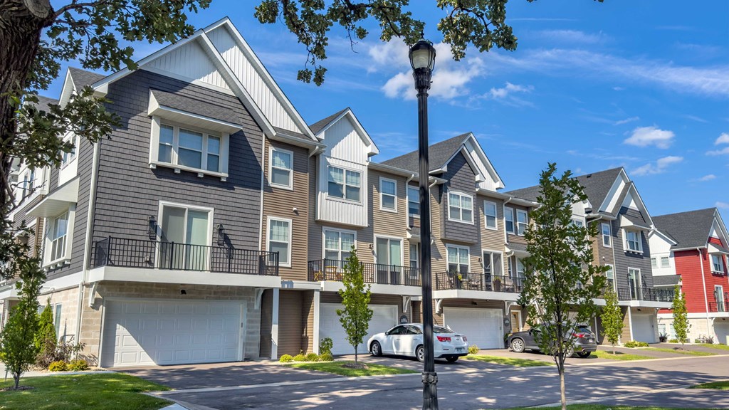 a row of houses with cars parked in front of them