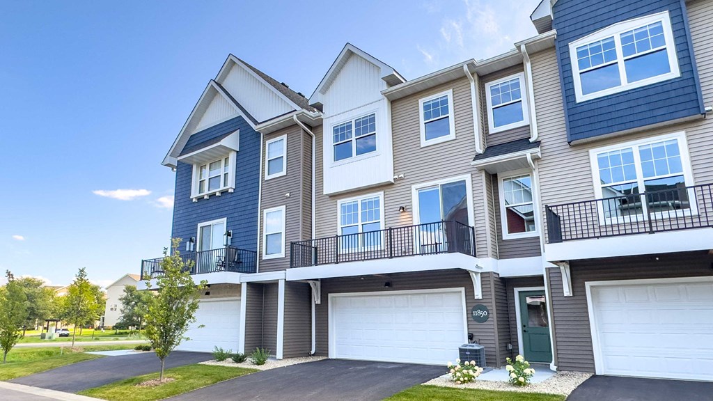the exterior of a townhouse with two garage doors