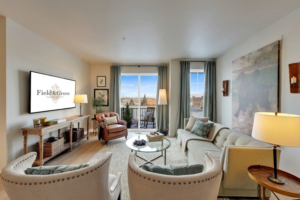 a living room with a couch and chairs and a tv