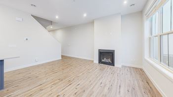 a living room with a wood floor and a fireplace