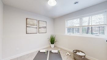 an empty room with yoga mats and a window