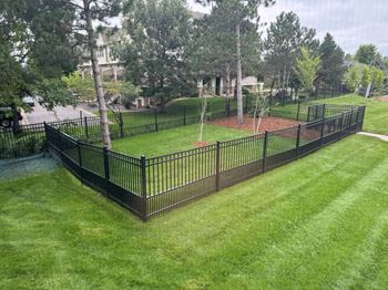 a yard with a black wrought iron fence