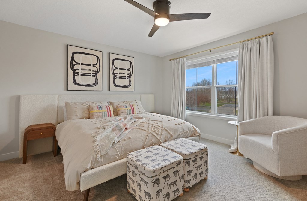 a bedroom with a bed and a ceiling fan