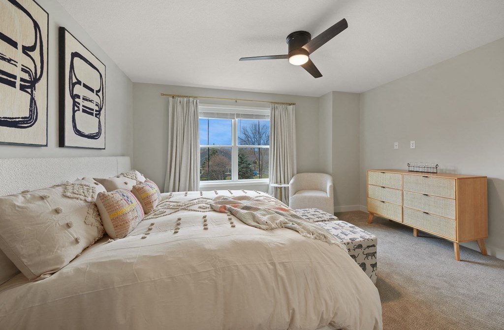 a bedroom with a bed and a ceiling fan
