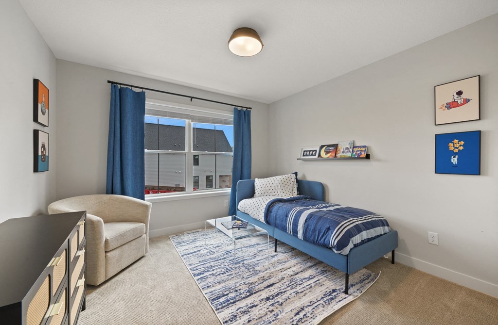 a bedroom with a bed and a window with blue curtains