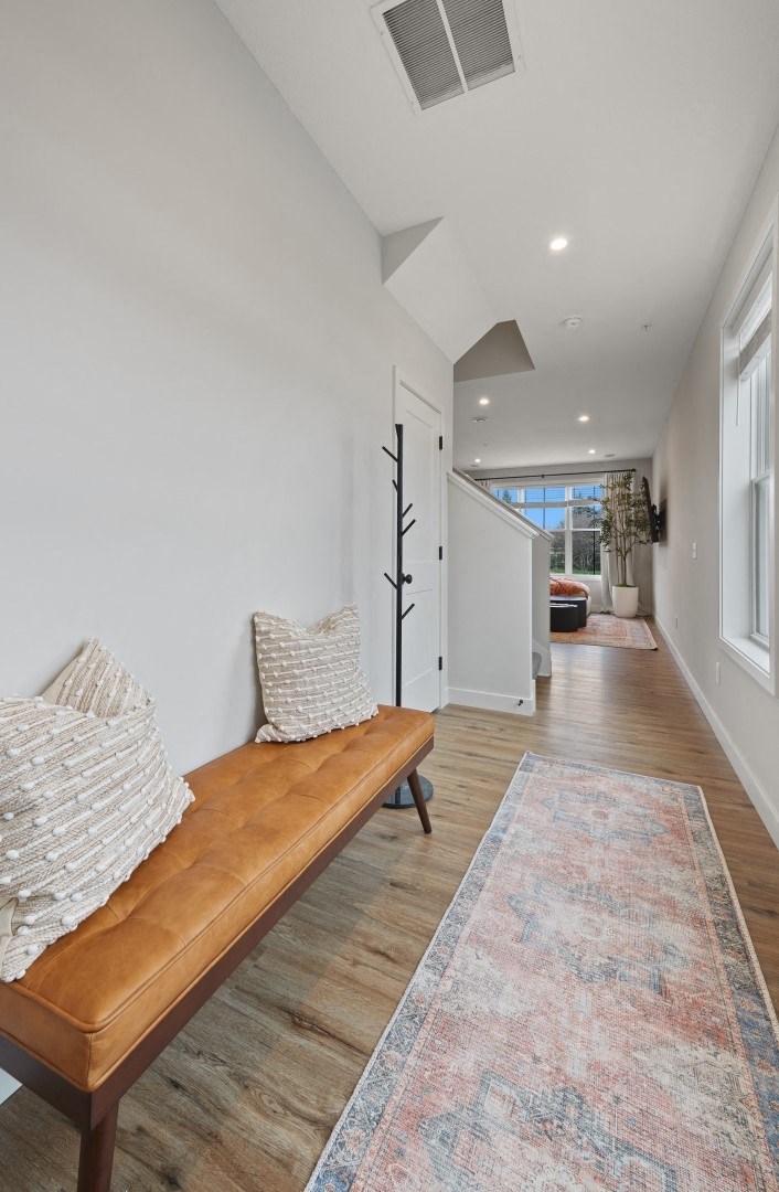 a living room with a wooden bench and a hallway in the background