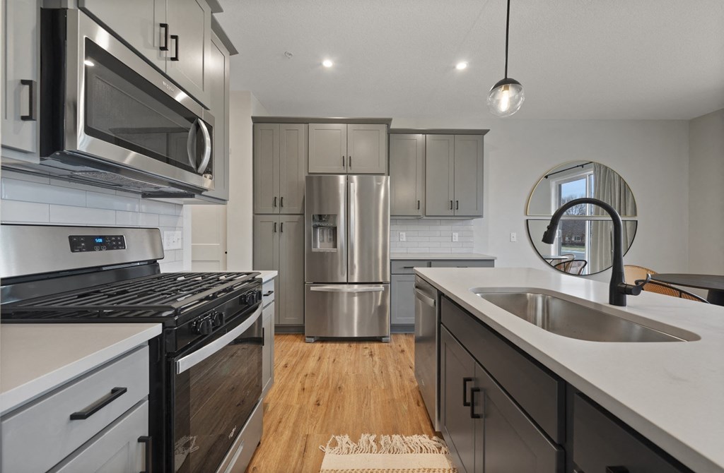 a kitchen with stainless steel appliances and white counter tops