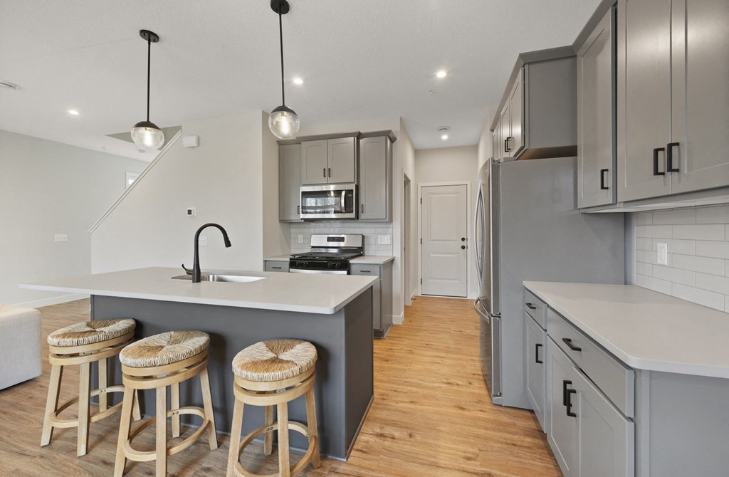 a kitchen with a center island and three stools