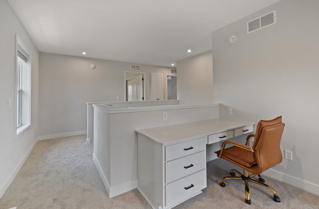a white office with a desk and a chair