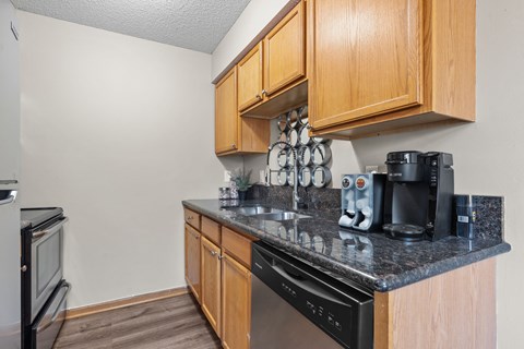 A kitchen with wooden cabinets and black appliances.