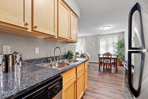 A kitchen with wooden cabinets and a black countertop.