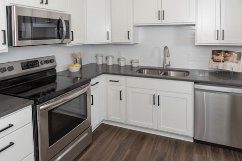 a kitchen with white cabinets and stainless steel appliances