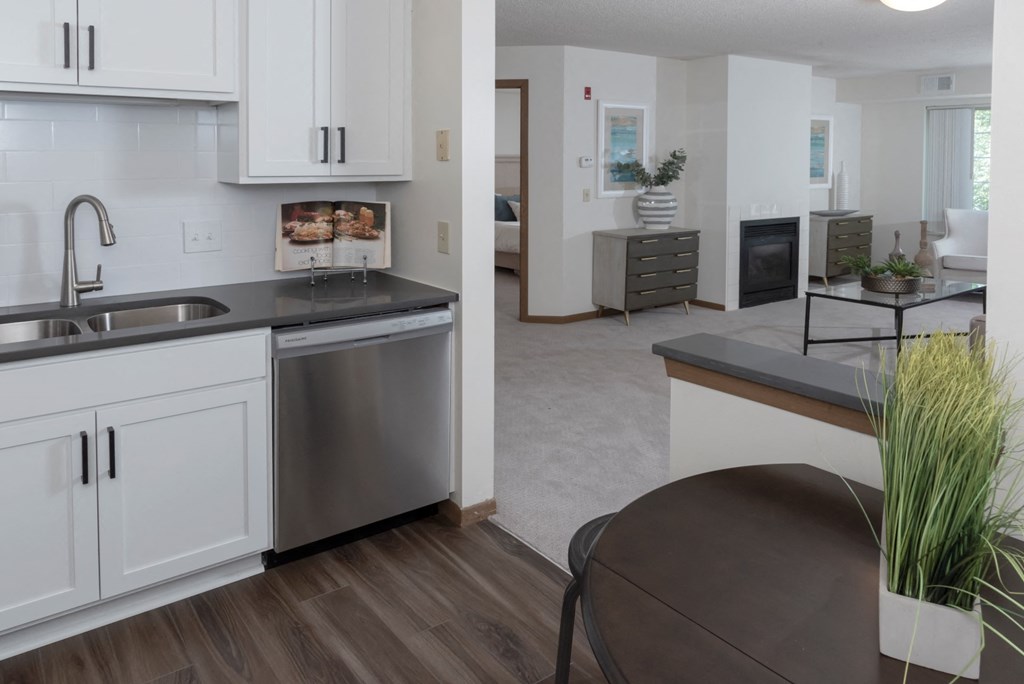 a kitchen with white cabinets and a stainless steel dishwasher