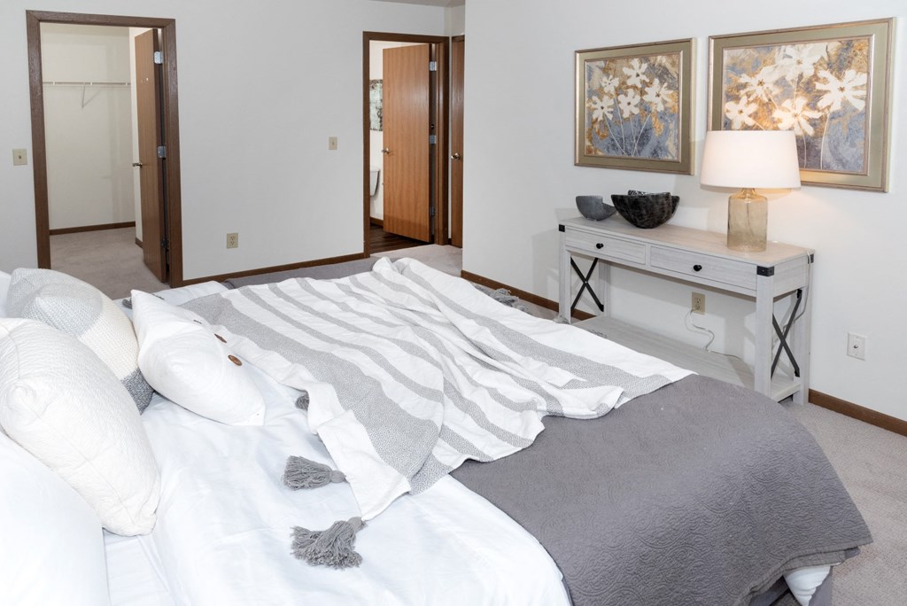 a bedroom with a bed and a desk with a lamp