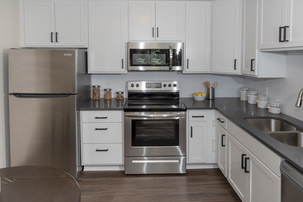 a kitchen with white cabinets and stainless steel appliances