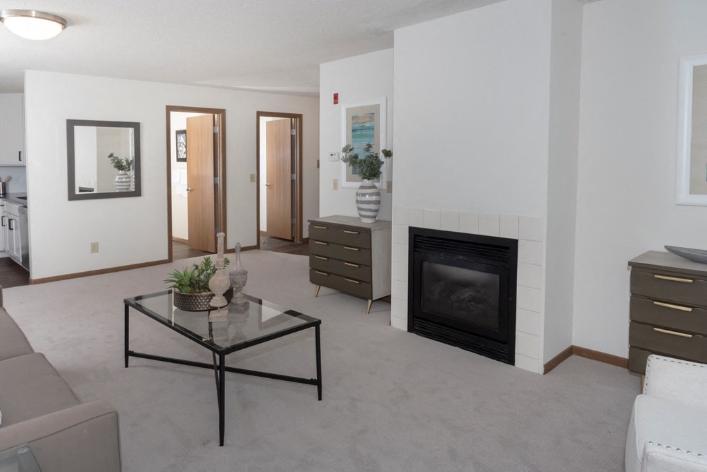 a living room with a fireplace and a glass coffee table