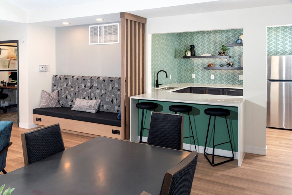 a kitchen with a black dining table and four black chairs