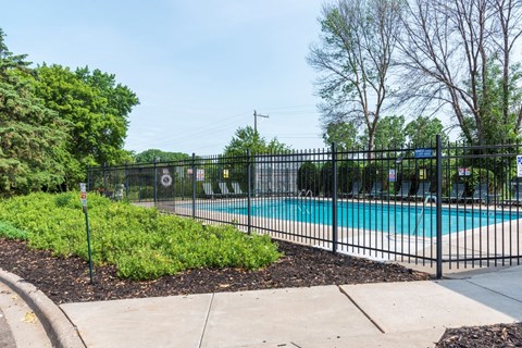 a swimming pool with a black fence in front of it
