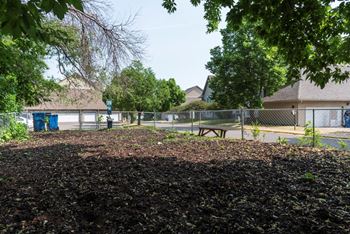 a park with a picnic table in front of a chain link fence