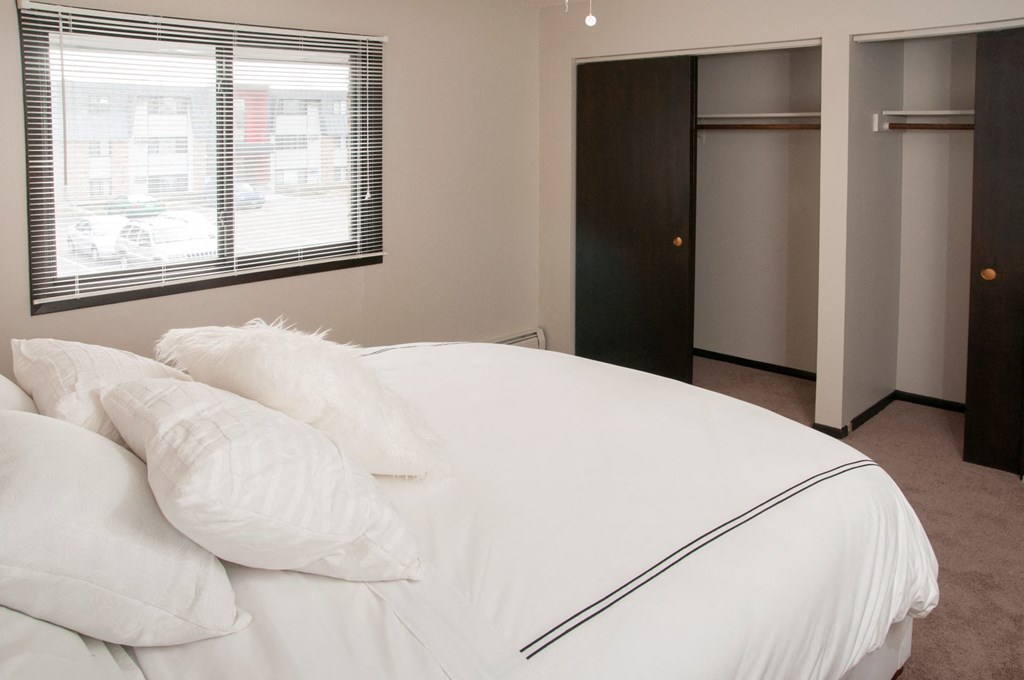 a bedroom with a large white bed and a window