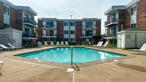 A swimming pool in front of apartment buildings.