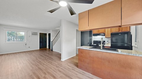 A kitchen with a black fridge and stove top oven.