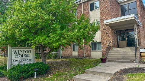 A brick building with a sign that says Winton House Apartments.