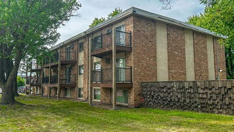 A brick building with a balcony on the second floor.