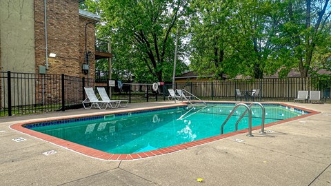 A small pool with a ladder and a fence around it.