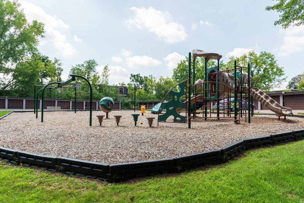 a playground with a climbing structure and picnic tables