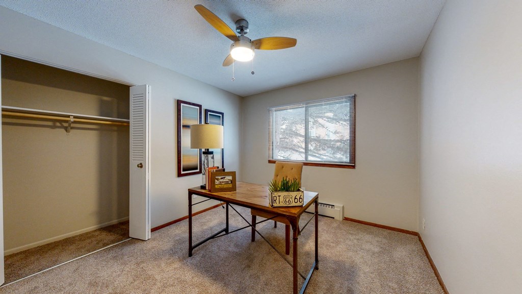 a living room with a ceiling fan and a window