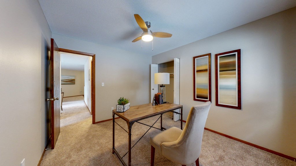 a desk with a chair and a lamp in a room