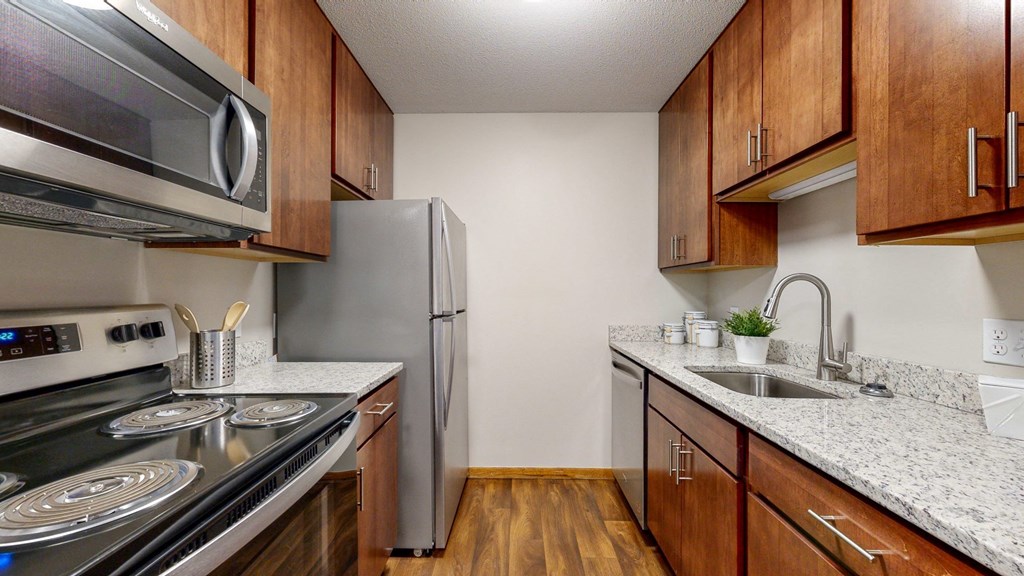 a kitchen with wooden cabinets and stainless steel appliances
