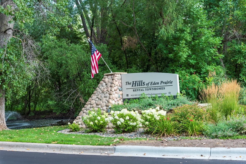a stone monument with a sign that says the hills of clear picture with an american flag