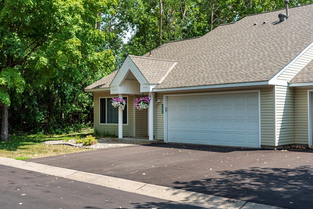 a house with a garage and trees in the background