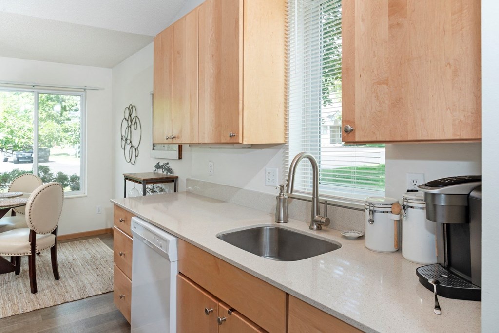 a kitchen with white countertops and wooden cabinets