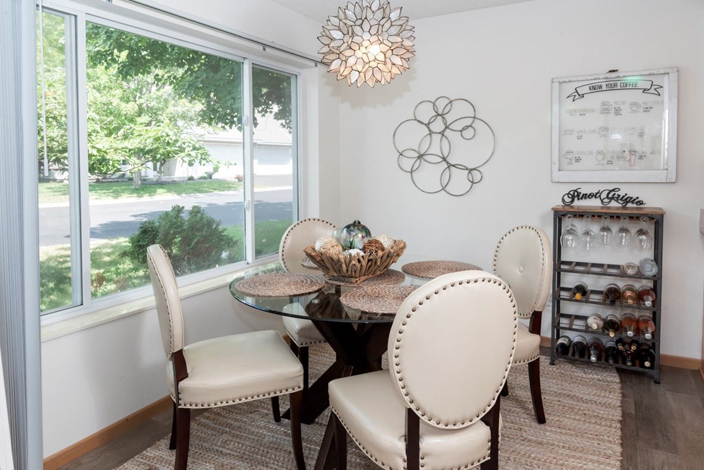 a dining room with a table and chairs and a large window