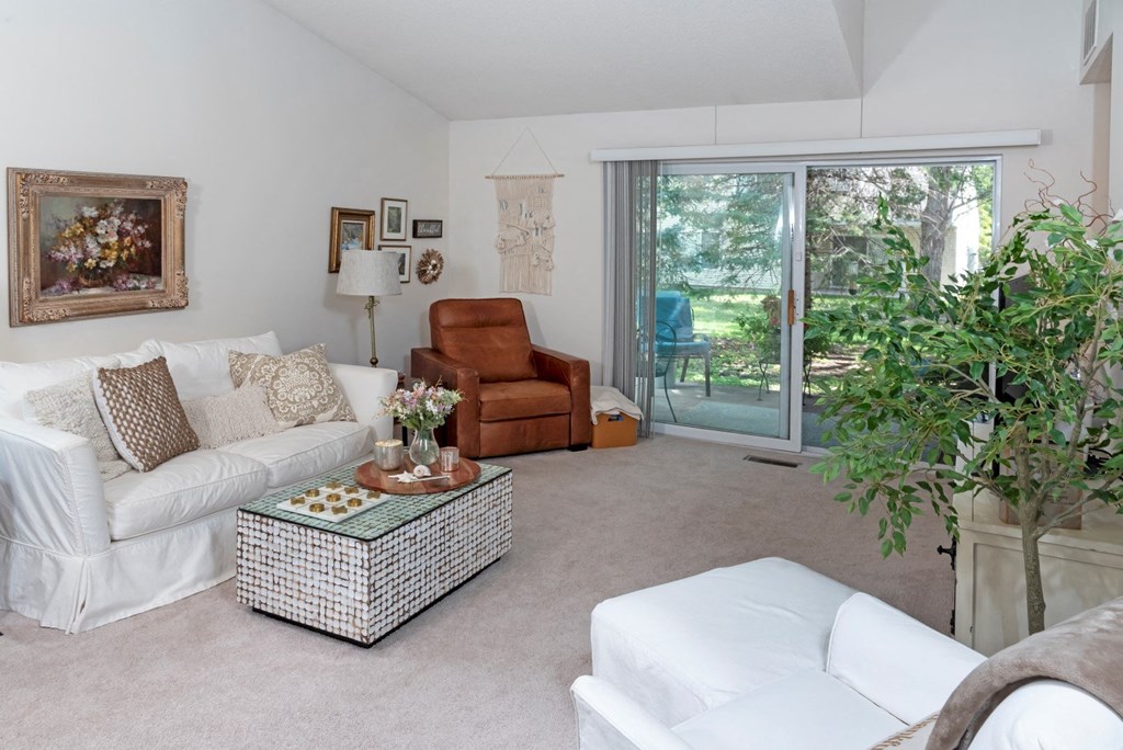 a living room with a white couch and a brown chair