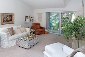 a living room with a white couch and a brown chair - Photo Gallery
